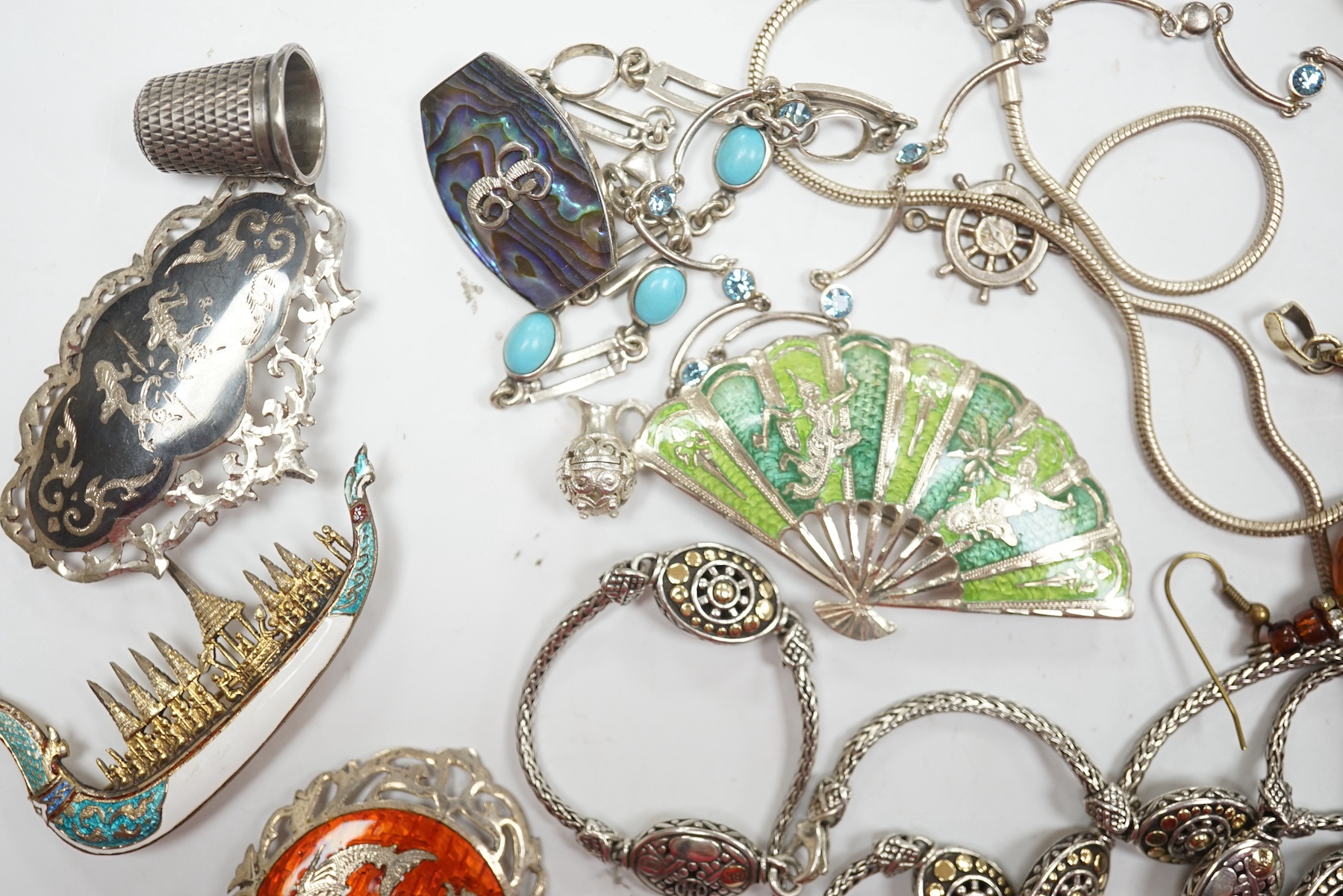 Assorted sterling , white metal and enamel jewellery including a charm bracelet, Siamese brooches, 925 and yellow metal necklace, etc. Condition - poor to fair to good